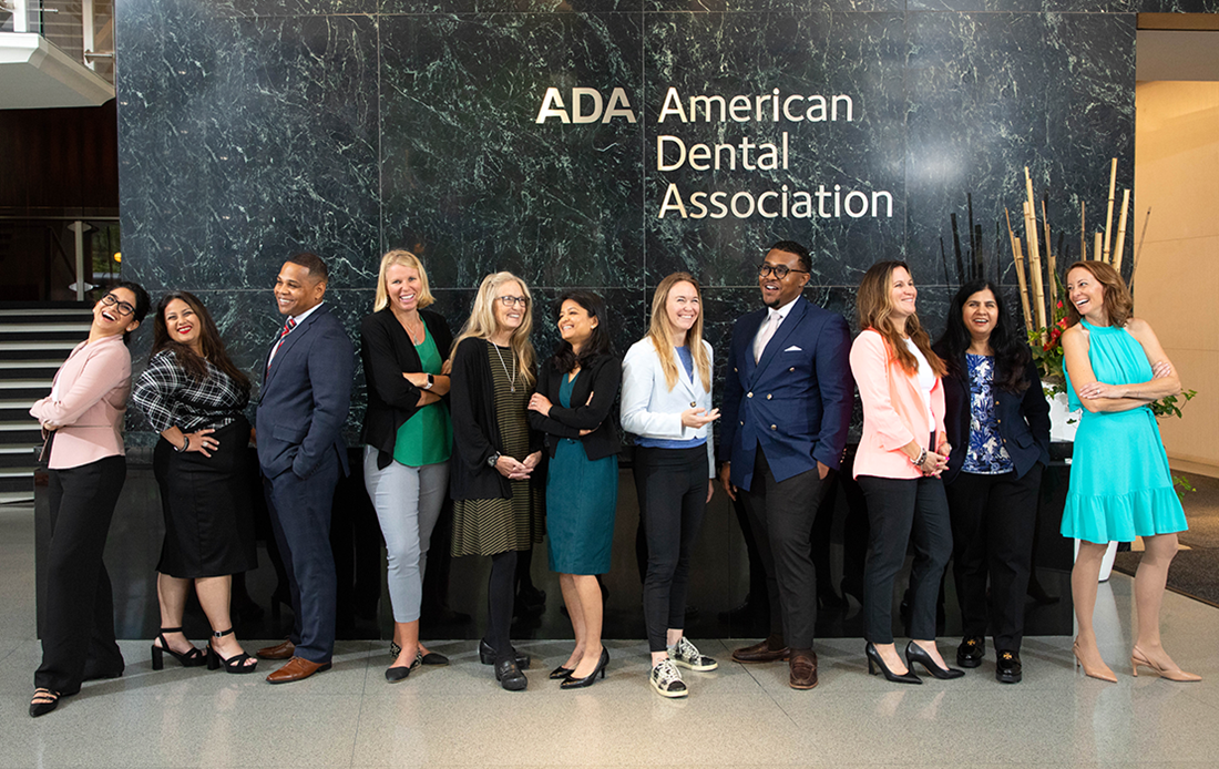 ADA Wellness Ambassadors Cohort 2 standing and smiling in front of an American Dental Association sign