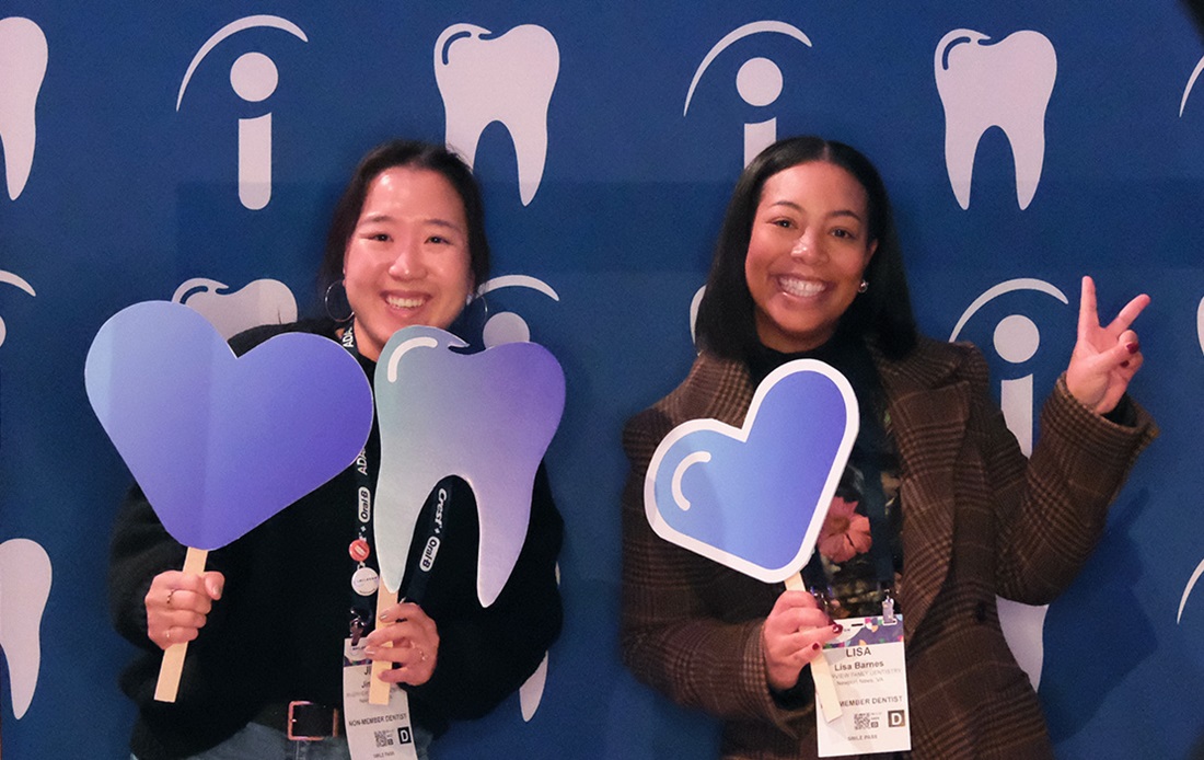 Two women holding tooth and hearts photo props