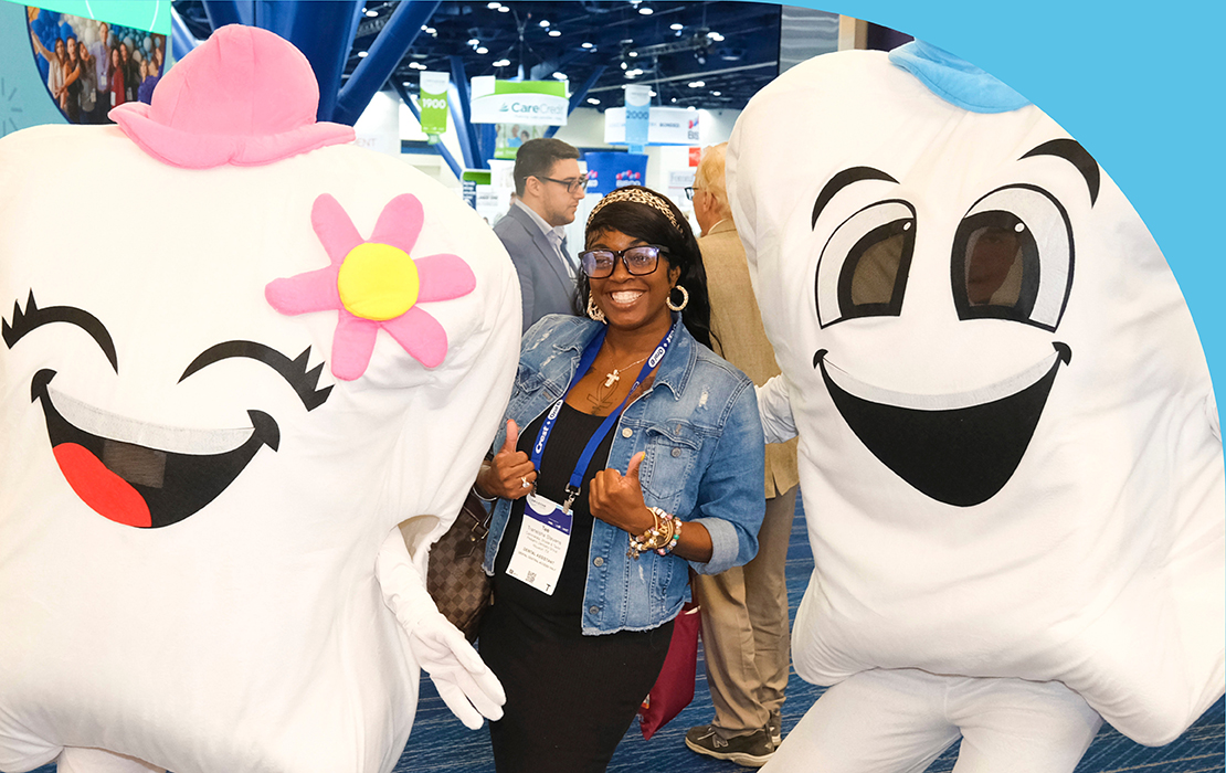 SmileCon attendee with two tooth-based mascots