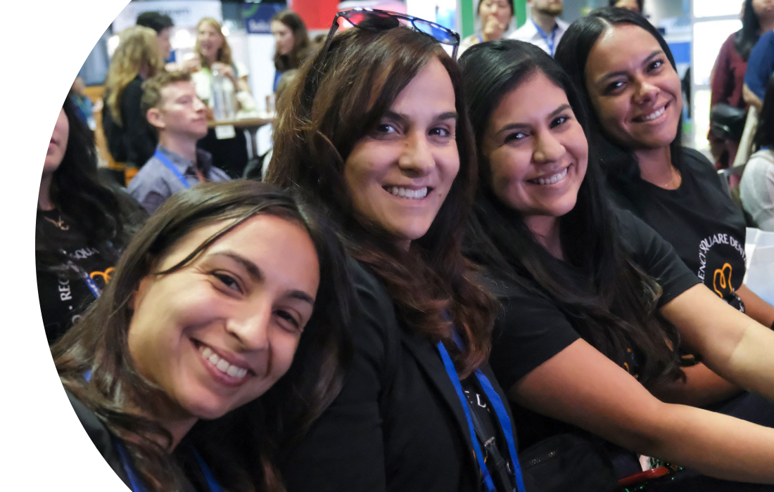 SmileCon attendees smiling for the camera while waiting for a presentation to begin