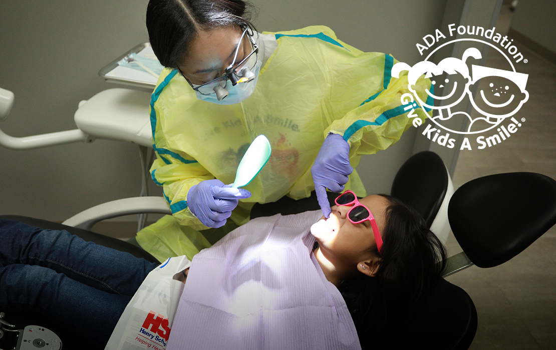 Dentist working on kid in dentist chair.