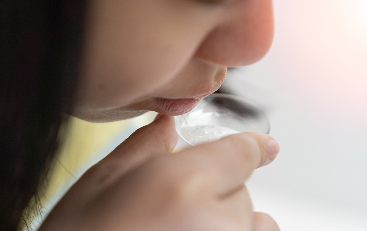 Image of a patient completing a saliva test.