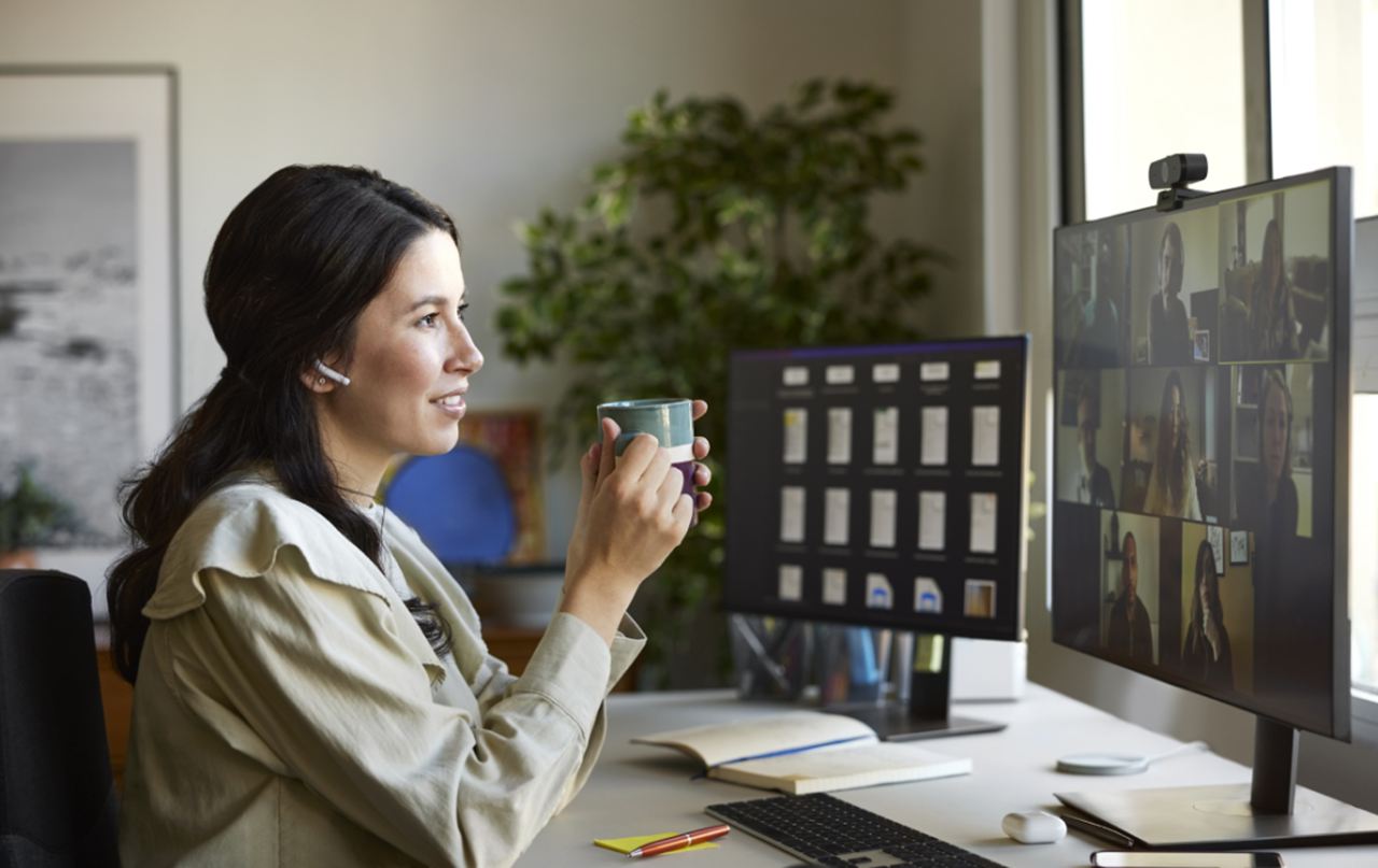 Woman sitting at a desk looking at her computer monitor.