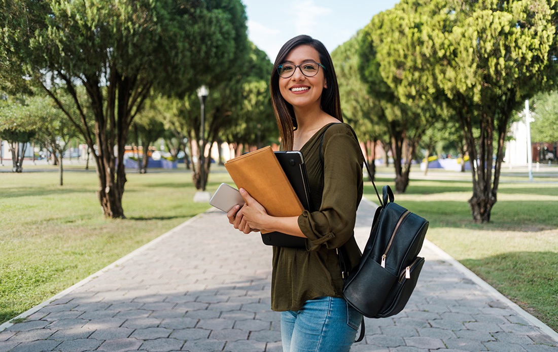 Female college student walking on a campus sidewalk