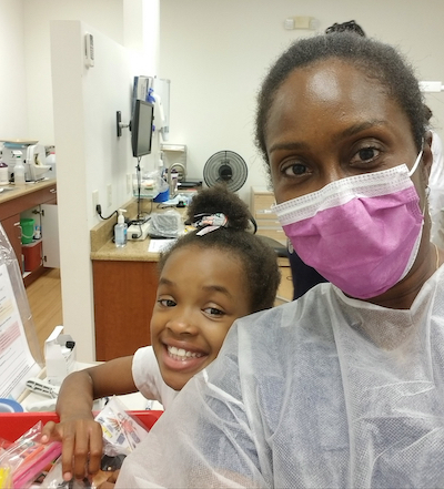 Dentist Nicole McGrath and young patient in her office