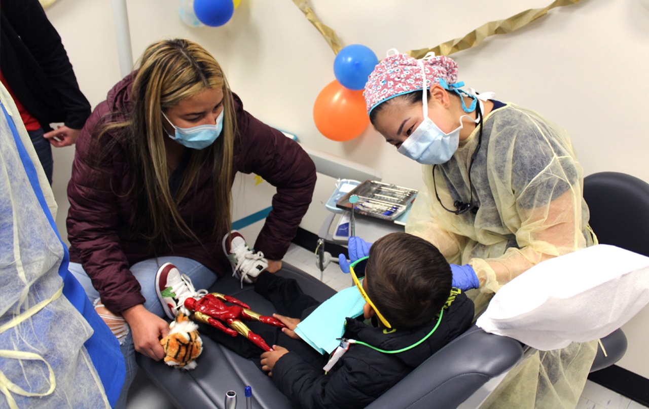 Pediatric dentist Janet Kim, D.D.S., treats a patient during GKAS event at Howard.