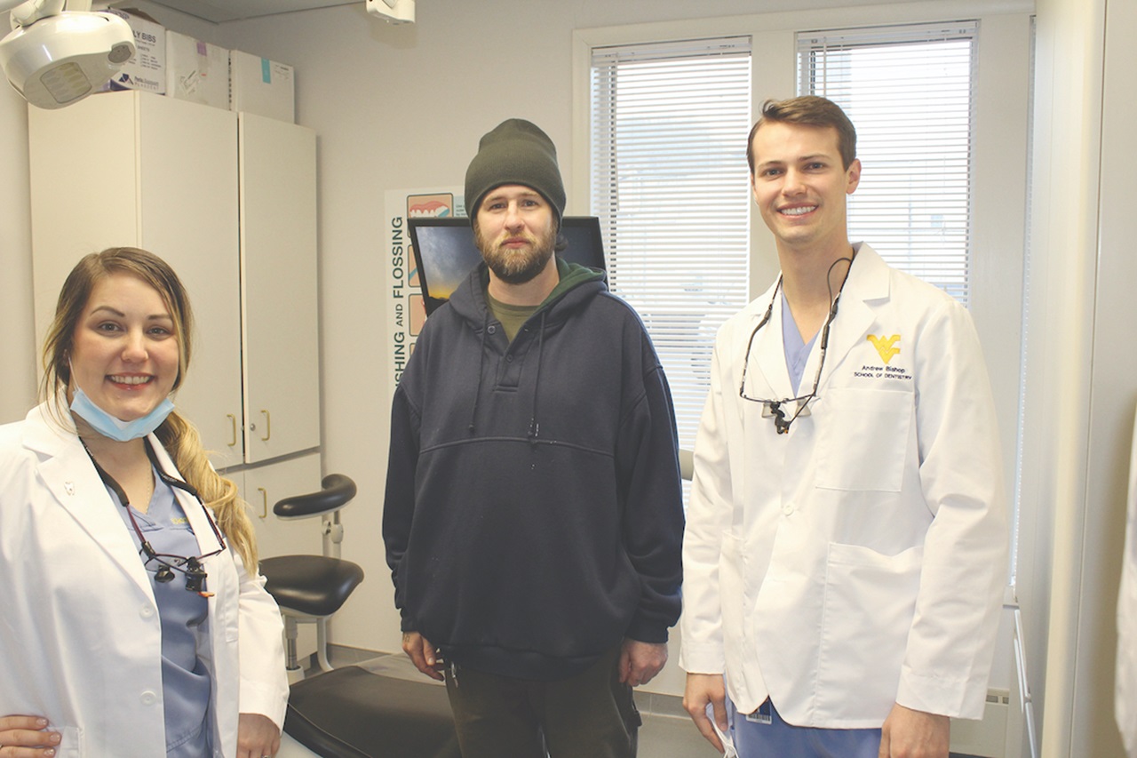 WVU dental students Brittany Carver and Andrew Barnes pose with a patient