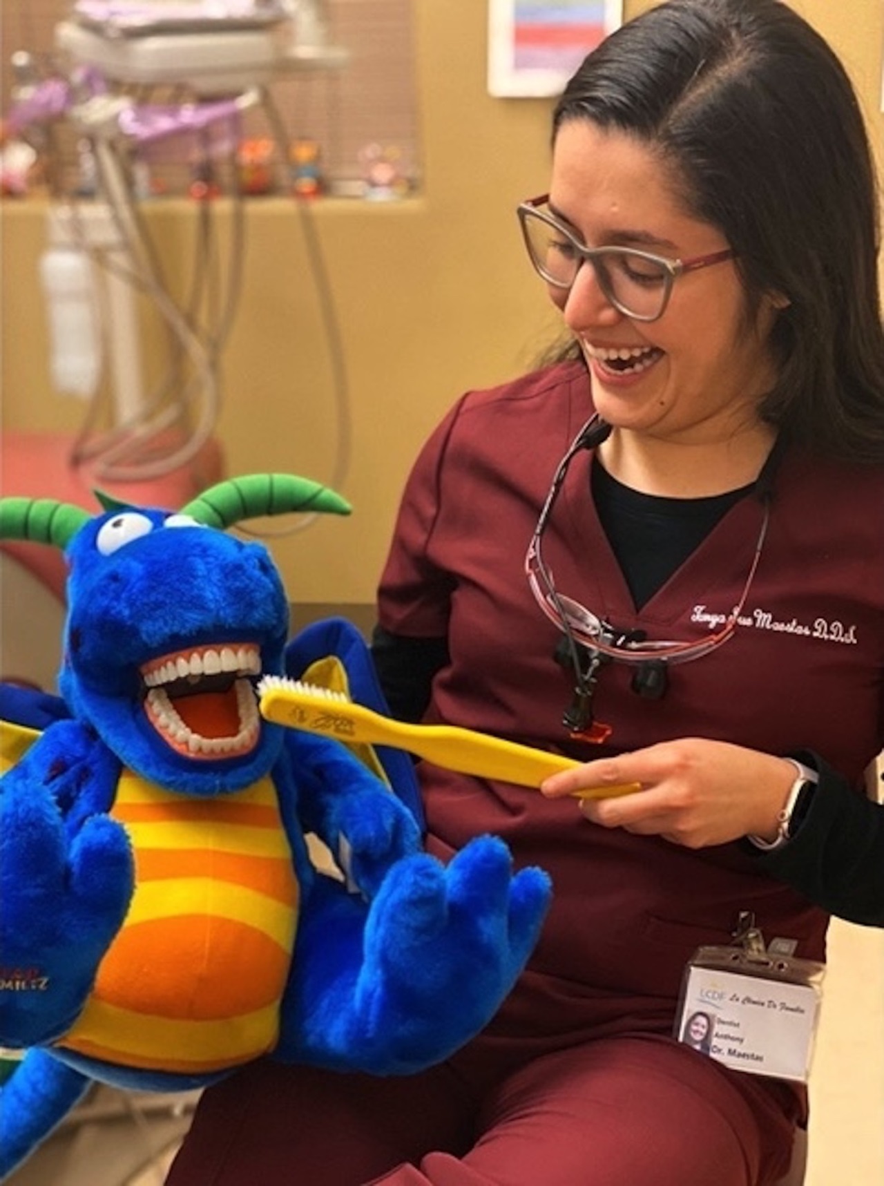Photo of Tanya Sue Maestas, D.D.S., brushing toy's teeth