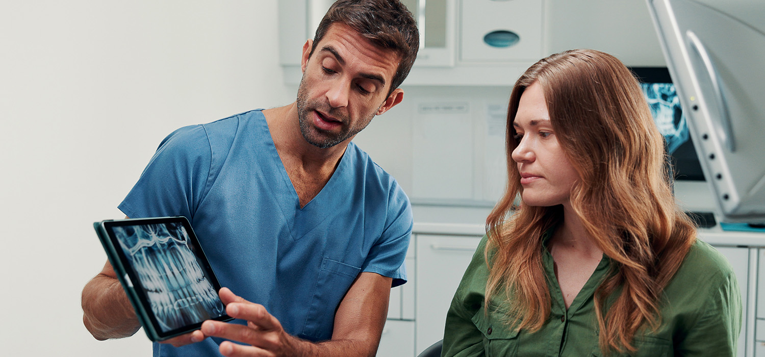 Dentist showing patient x-ray.