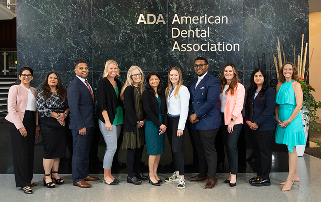 Wellness Ambassadors standing in front of an American Dental Association sign.