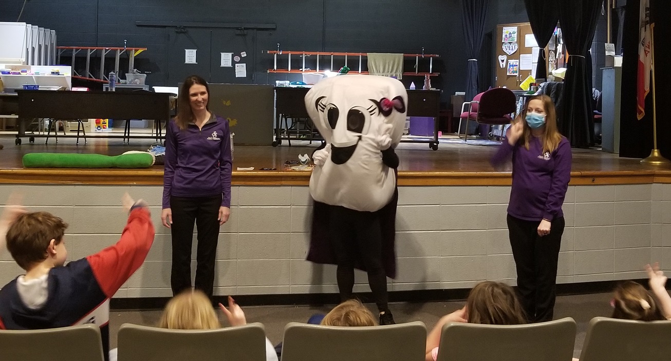 A photograph of tooth mascot answering kid's questions on Stuefen Tooth Day at a grammar school.