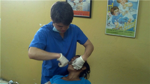 Dentist abstracting teeth in dental office