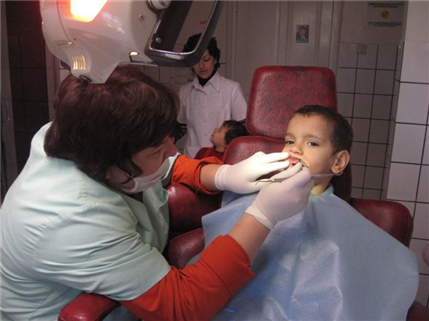 Dentists examinig small boy