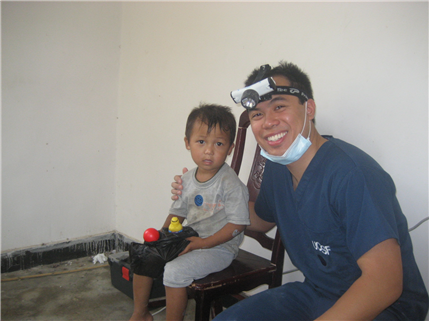 Dentist smiling with small boy in chair