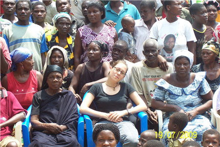 Group of people sitting in chairs with one volunteer 