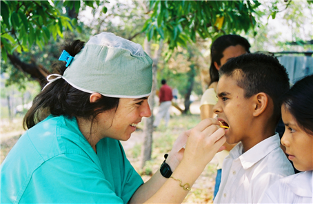 Female dentist examining small boy