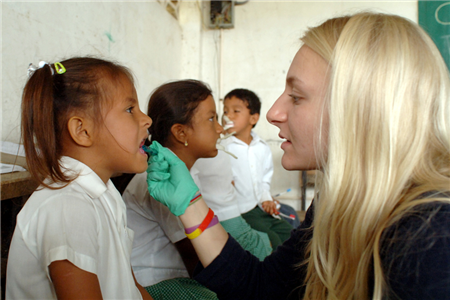 dentist with hand in girls mouth