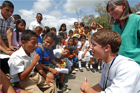 boy brushing while dentist looks on