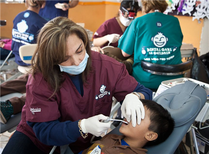 dentist examining small boy in dental chair