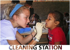 clinician cleaning young girls teeth