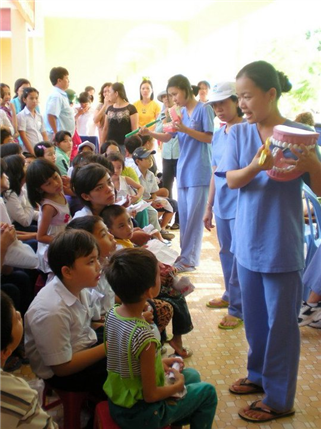local instructor with large mouth model teaching dental hygiene