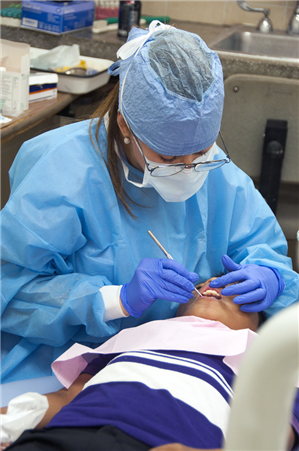 Dentist treating small boy in chair