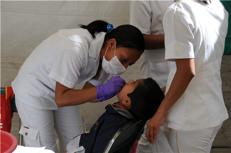 Dentist treating young boy in chair
