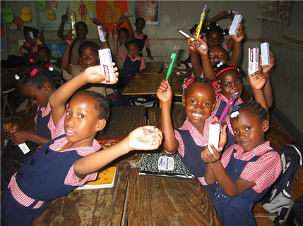 Children in Jamaica holding up toothbrushes
