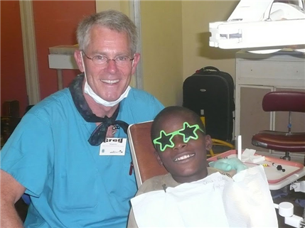 Dentist with Jamaican patient who has star sunglasses on
