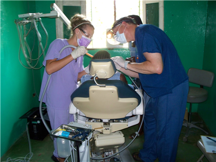 Dentist and assistant treating patient in chair