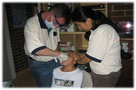 Dentist extracting tooth of boy