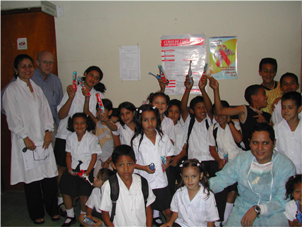 Children in dental clinic holding up toothbrushes