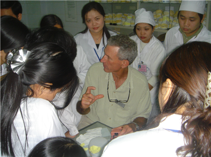 Dentist teaching local professioals around chair