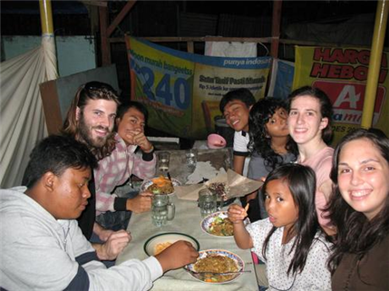volunteers with locals at dinner table