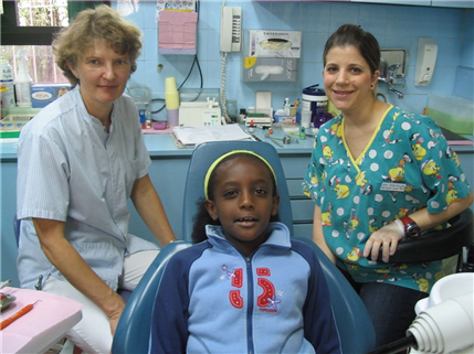 Two dentists with patient sitting up in chair