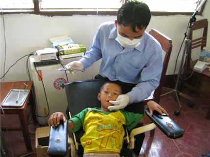 Little boy in dental chair with dentist behind him