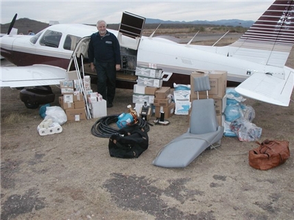 Dental supplies outside of plane with volunteer