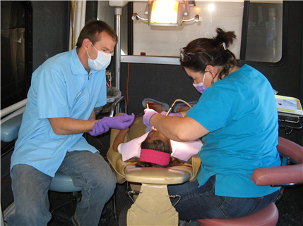 Dentist doing chairside instruction with patient in chair