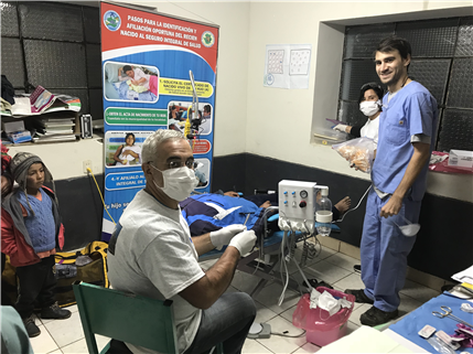 Photo of dental clinic with patients in chairs and supplies on a table