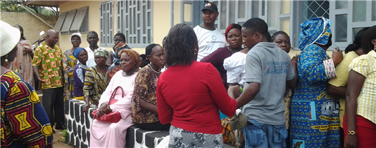 Photo of a group of adults in colorful clothing outside of a building