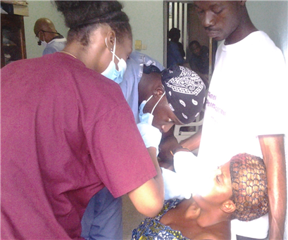 Photo of dental clinic with volunteers providing care to a patient