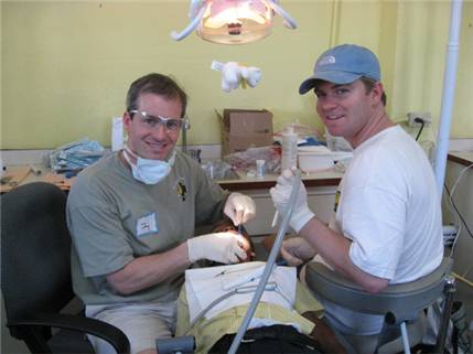 Photo of two dental volunteers providing care to a child