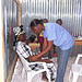Photo of dental volunteer observing a patient in a chair