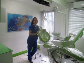 Photo of dental team member posing by a green and white dental chair