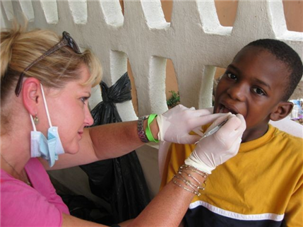 Photo of dental volunteer examining a child's teeth