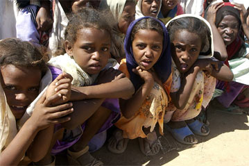 Photo of four concerned-looking children in a crowd