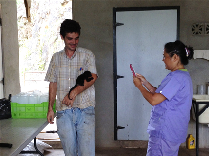 Photo of person with a monkey clinging to his arm