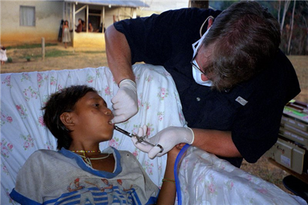 Photo of dental volunteer providing care to a young person 