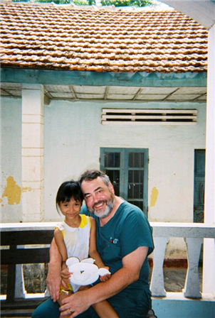 Photo of a volunteer and a child outside of a building