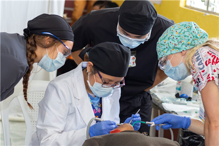 Dentist and students treating patient